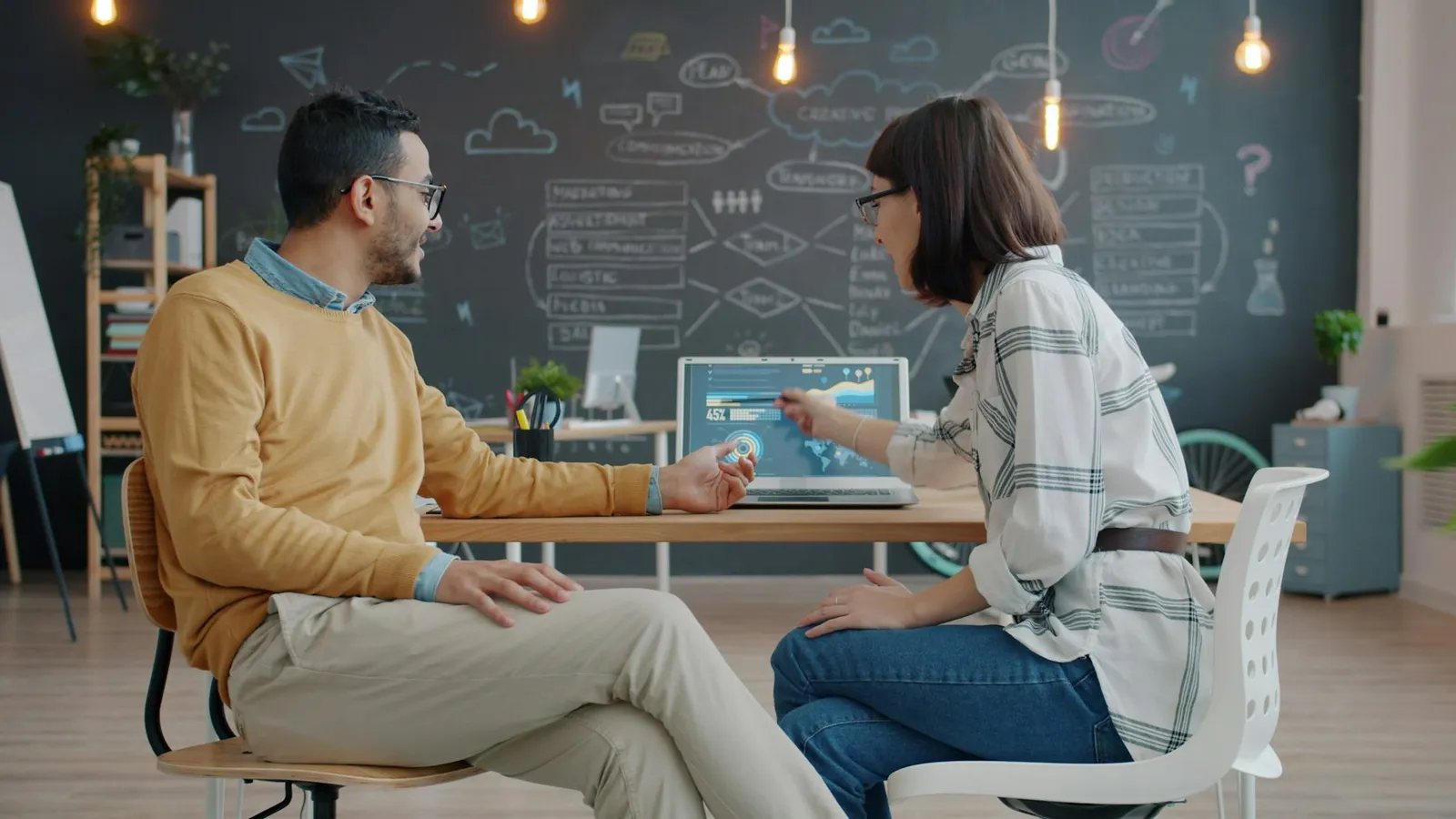 Two colleagues talking through a dashboard
