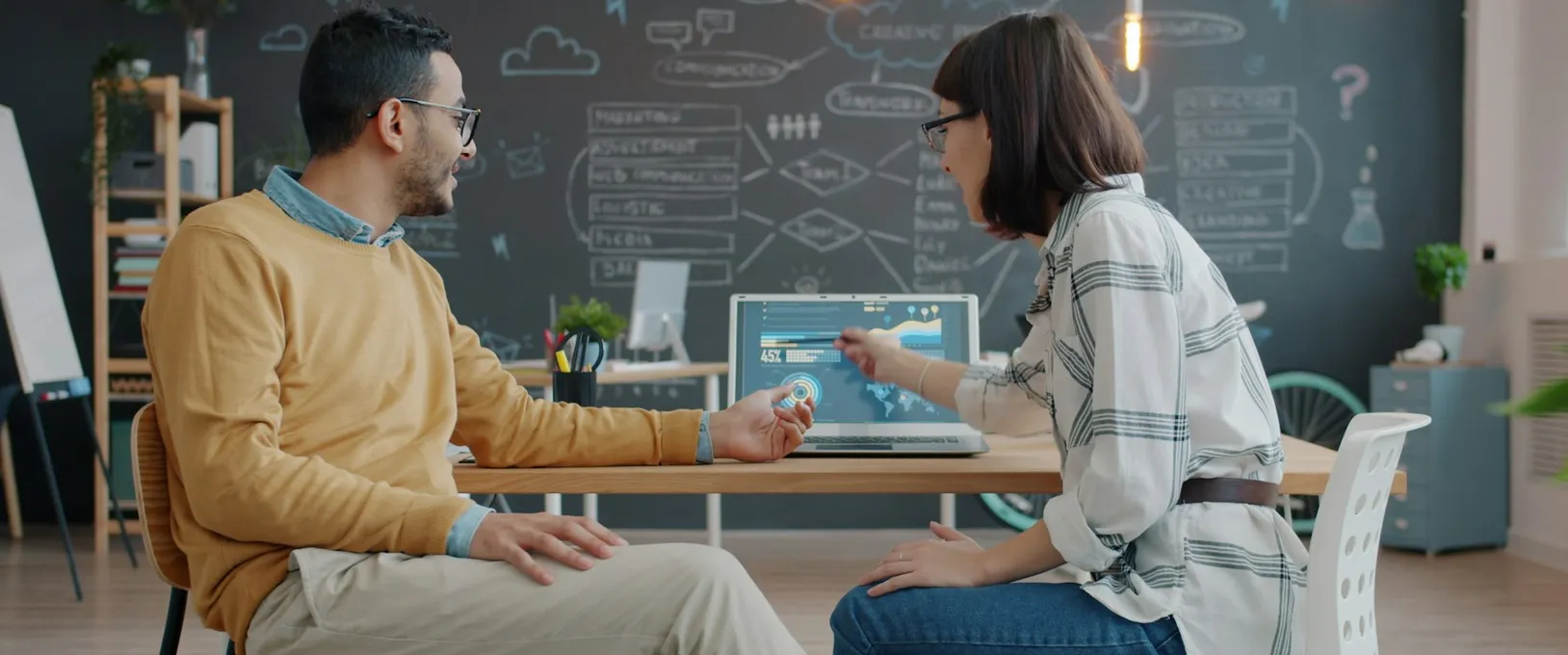 Two colleagues talking through a dashboard