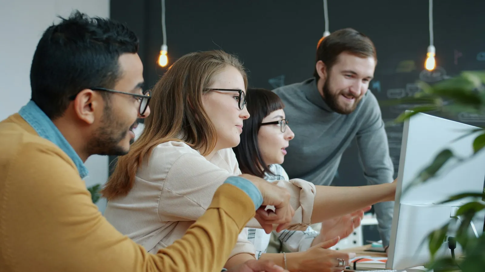 A team reviewing work on a monitor