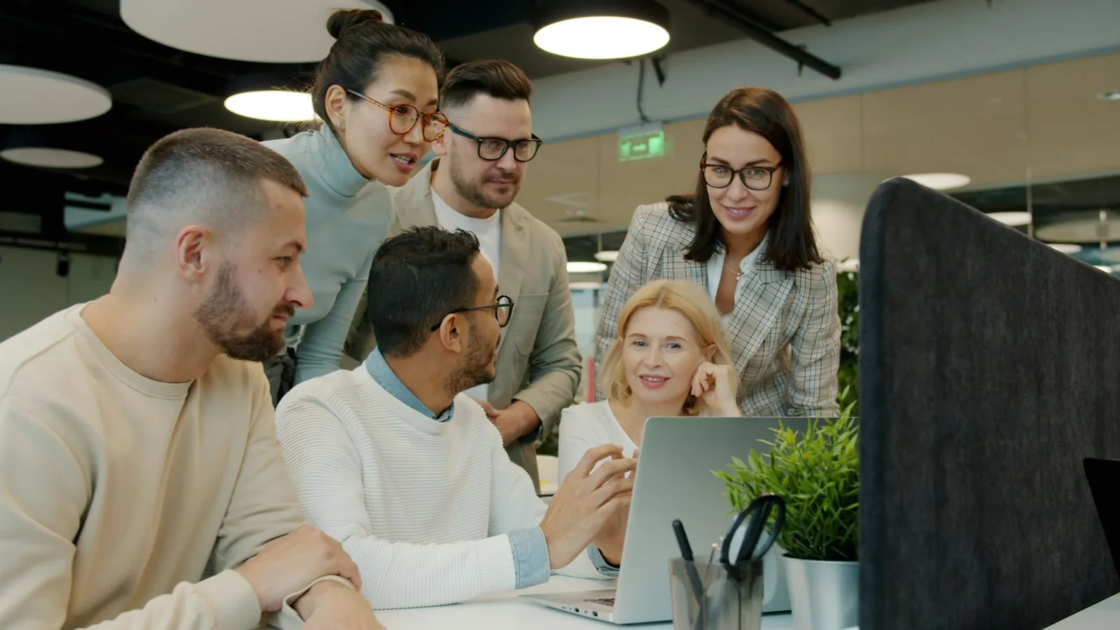 An enterprise team gathered around a laptop